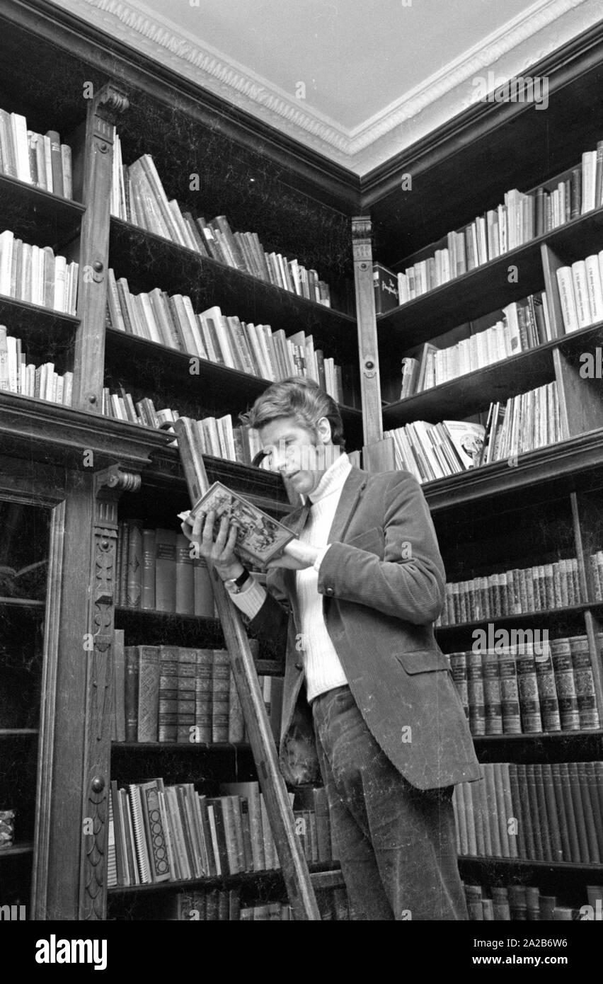 Rudi Carrell mit geöffnete Buch auf einer Leiter in eine Bibliothek. Stockfoto