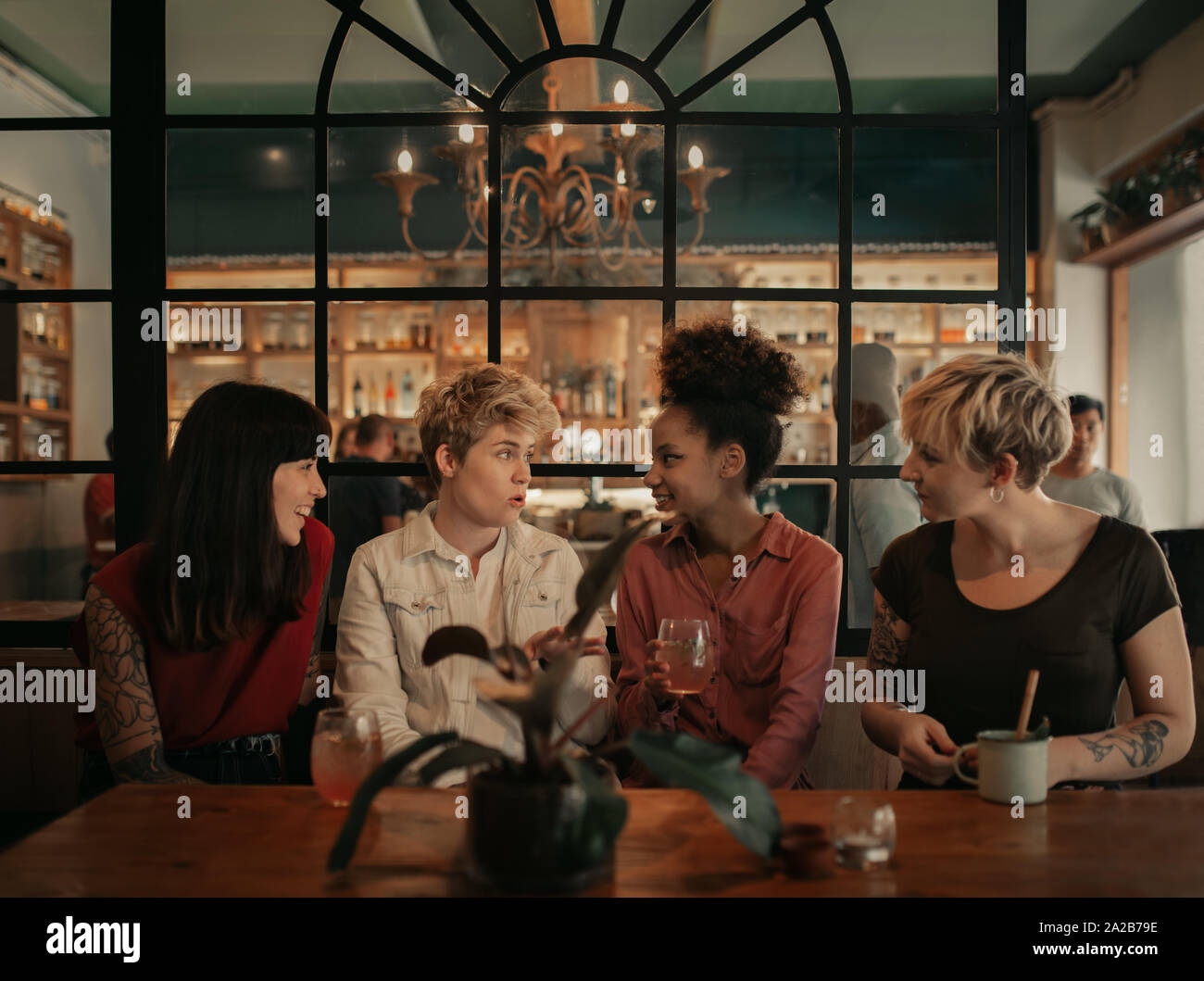 Vielfältige Gruppe von Freundinnen sprechen über Getränke in einer Bar Stockfoto