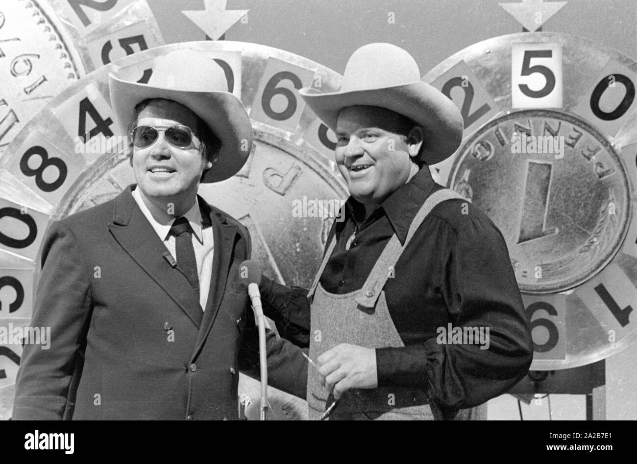 Wim Thoelke und der Imitator von Hoss aus der Fernsehserie Bonanza, Dan Blocker, in der Fernsehsendung 3x9. Die glücklichen Räder in Form der Deutschen Mark und des Pfenning sind die Symbole der Aktion Sorgenkind. Stockfoto