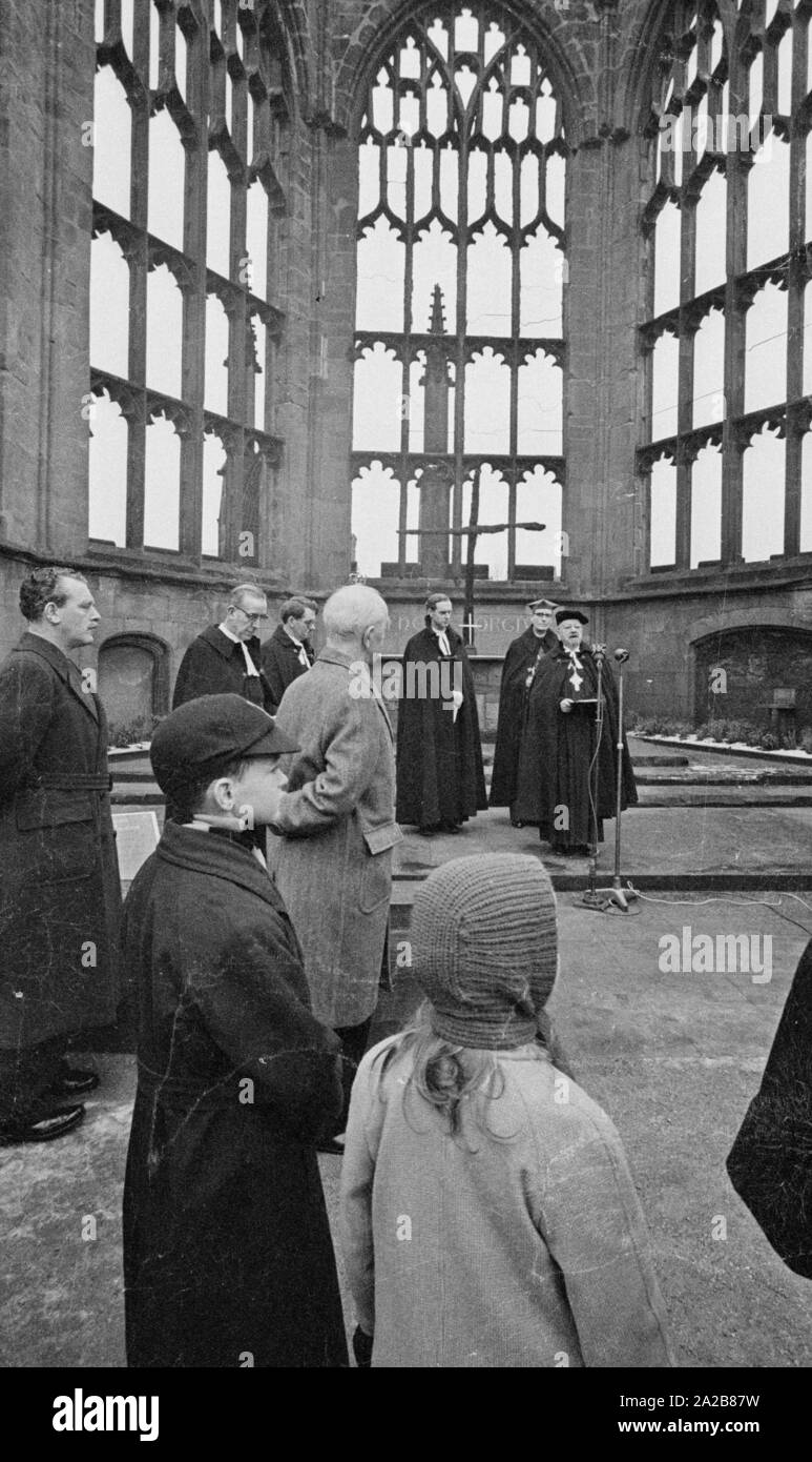 Der deutsche Bischof Otto Dibelius, gibt eine Rede, in der Ruine der Kathedrale von Coventry (Kathedrale Kirche des Hl. Michael) anlässlich der Grundsteinlegung für das "Internationale Zentrum für Versöhnung" an der gleichen Stelle. Hinter ihm auf der linken Seite, Reverend Bill Williams, der Pastor von conventry. Im Hintergrund auf dem Altar, dem Verkohlten Kreuz und das Kreuz der Nägel. Stockfoto