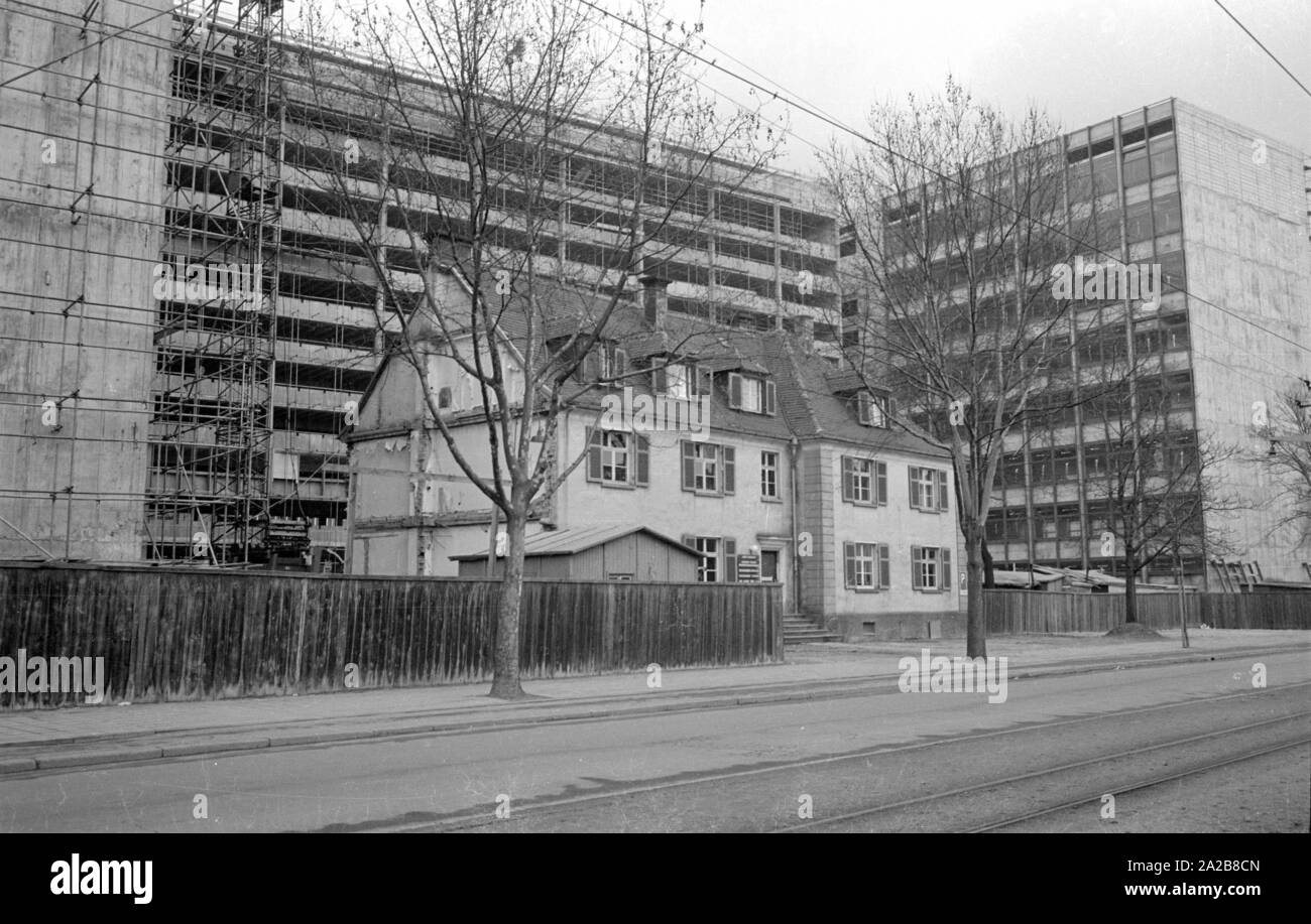 Bau eines neuen, grossen Wohnanlage in München. Das alte Haus im Vordergrund hat vor dem Abriss bisher verschont geblieben. Stockfoto