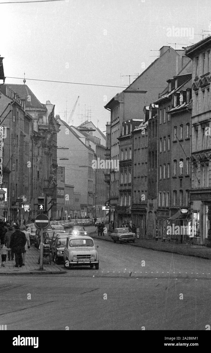 Ansicht der Sendlinger Straße in München, wo es viele Geschäfte. In der Mitte der linken Reihe der Häuser ist die barocke Asamkirche. Stockfoto