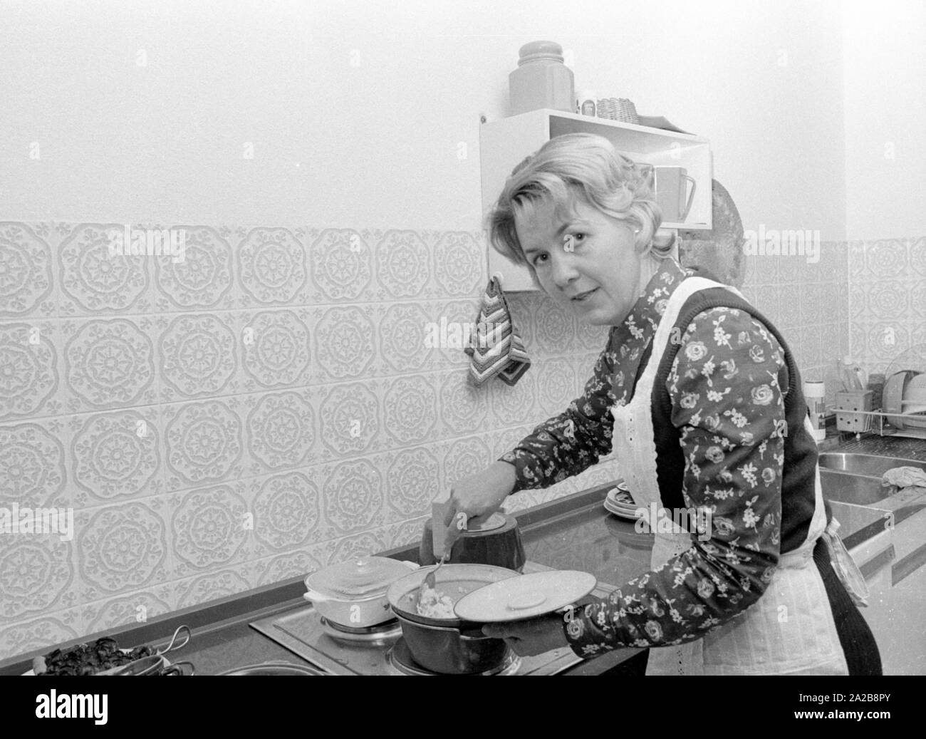 Eine Frau bereitet eine Mahlzeit in der Küche ihrer Heimat. Stockfoto