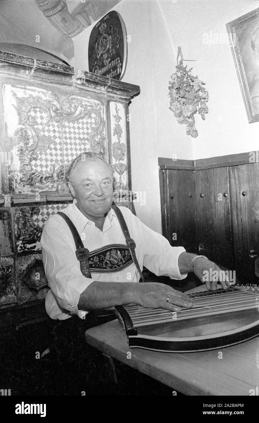 In einem Restaurant im bayerischen Kurort ein Mann spielt auf eine Kastenzither. Stockfoto