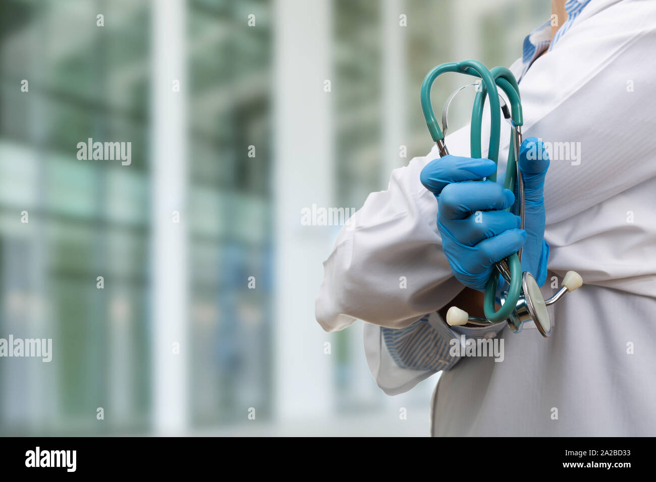 Zuversichtlich Ärztin mit verschränkten Armen holding Stethoskop Stockfoto