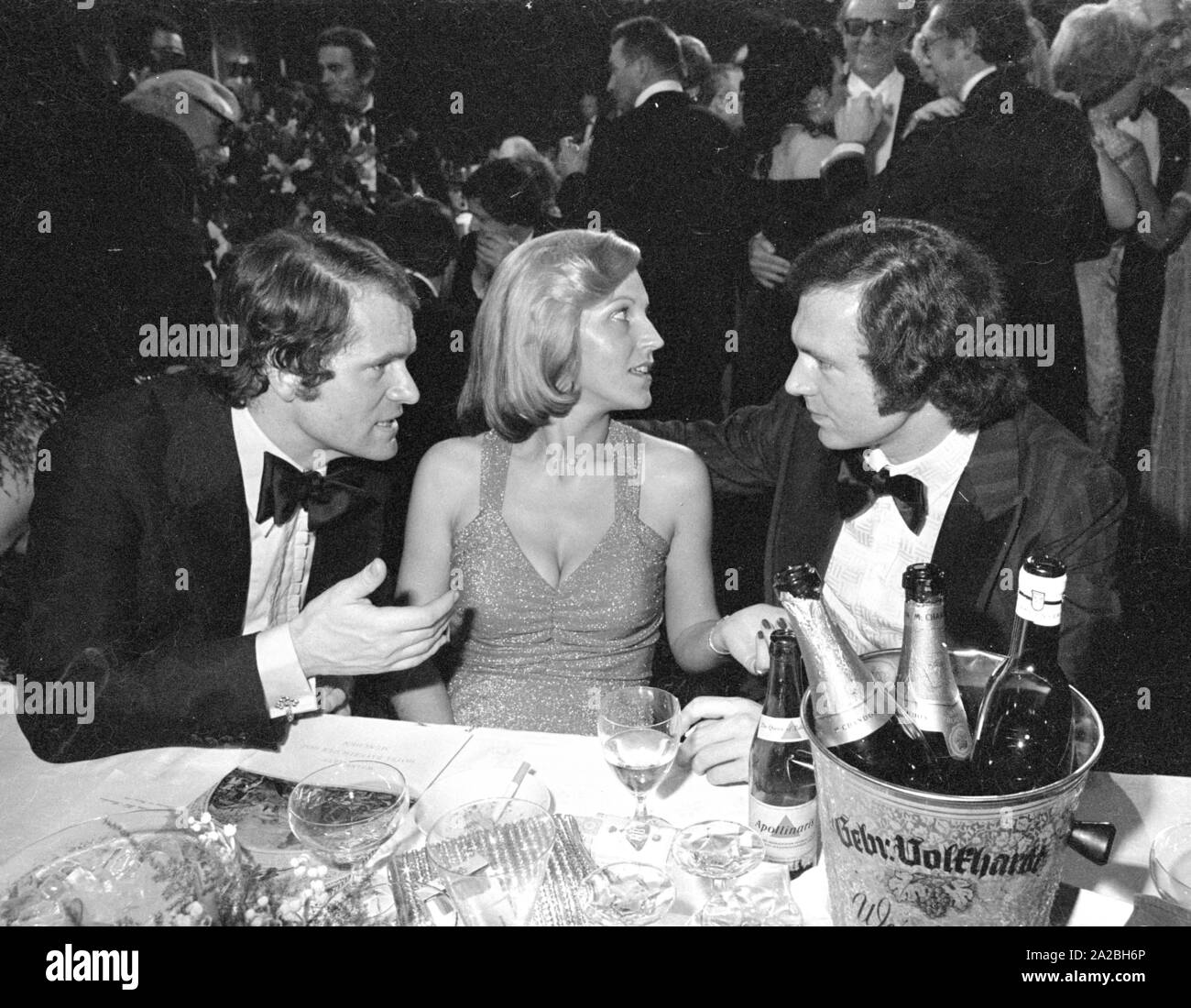 Die deutschen Fußballer Wolfgang Overath (l.) und Franz Beckenbauer (r) im Rahmen einer Gala in München. In der Mitte: Brigitte Beckenbauer. Stockfoto