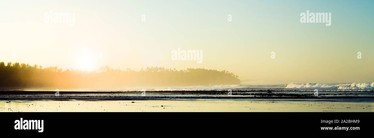 Küsten Spray über einen Strand bei Sonnenaufgang Panoramablick Stockfoto