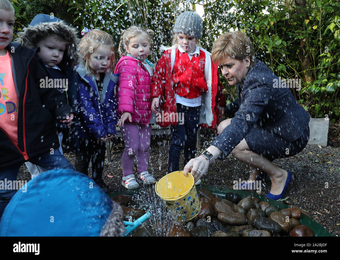Erster Minister Nicola Sturgeon mit Kindern spielen im Wasser während eines Besuchs in Sauchie Kindergarten in Alloa, um zu hören, wie es bereitet sich auf die Erweiterung der frühen Jahre und der Kinderbetreuung. PA-Foto. Bild Datum: Mittwoch, 2. Oktober 2019. Photo Credit: Andrew Milligan/PA-Kabel Stockfoto