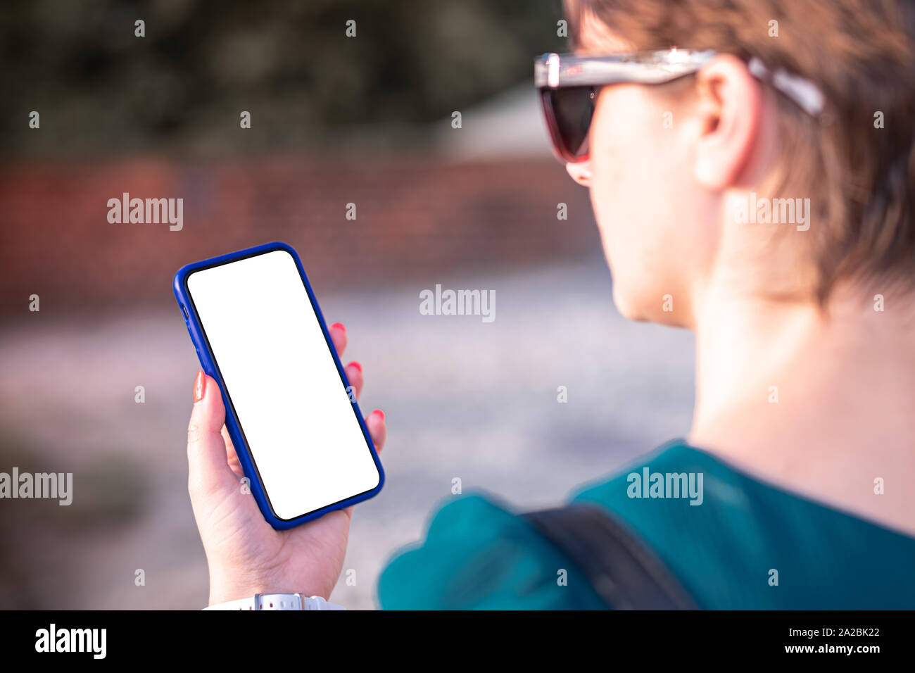 Frau mit Smartphone mit leeren Bildschirm. Vorlage, Mockup, Design. Stockfoto