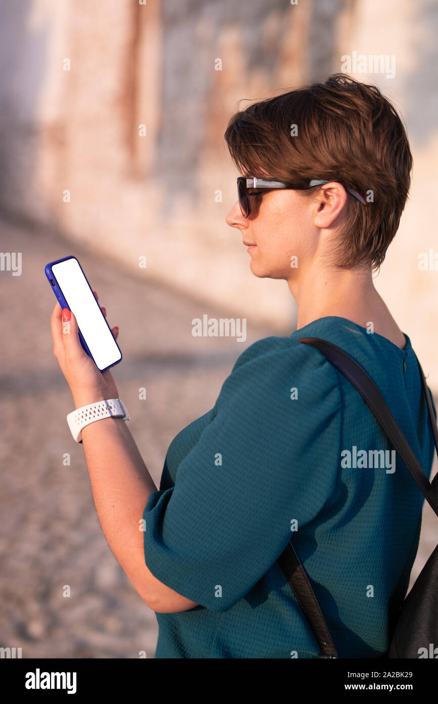 Frau mit Smartphone mit leeren Bildschirm. Vorlage, Mockup, Design. Stockfoto