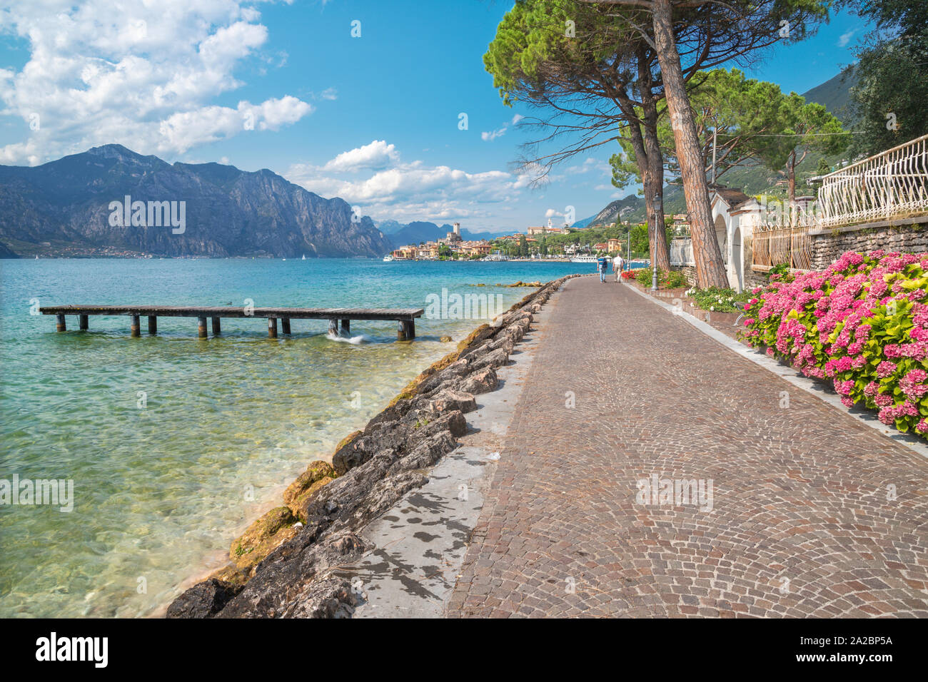 Malcesine - die Promenade über den Lago di Garda See, die Stadt und die Burg im Hintergrund. Stockfoto