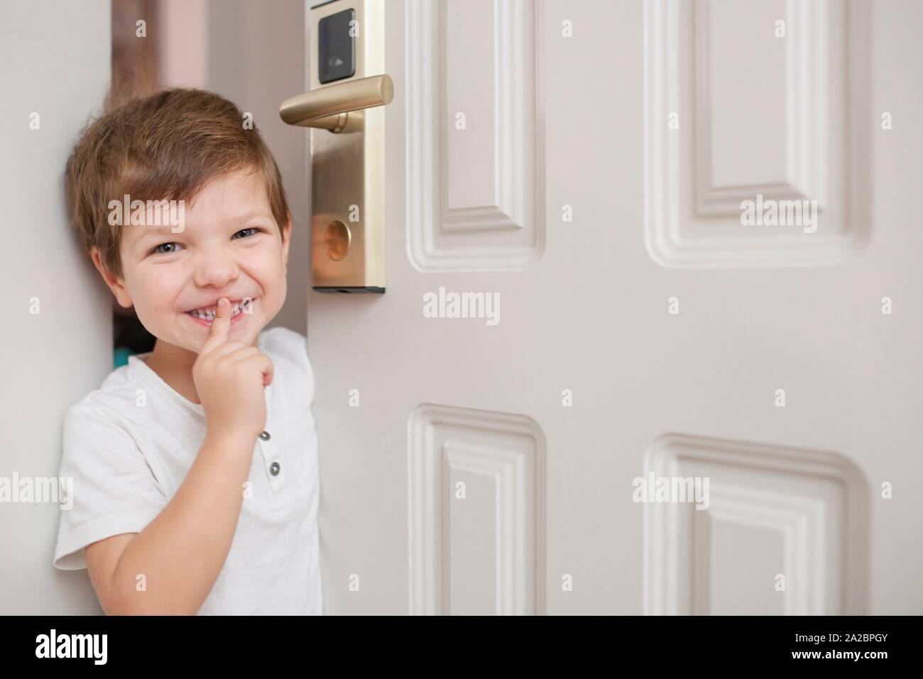 4 Jahre alt in Tür und stille Zeichen mit der Hand. Er ist nur über der Tür Hotel Zimmer schließen. Soft Focus. Stockfoto