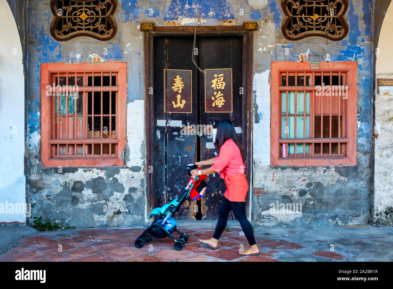 Frau vor einem alten Geschäftshaus in Georgetown, Penang, Malaysia Stockfoto