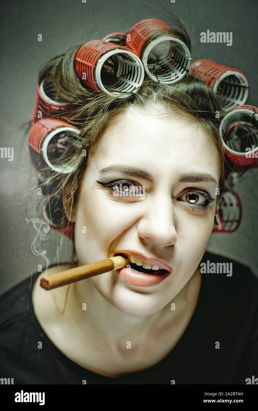 Gefährliche Sachen. Lustige Frau Porträt mit grossen Zigarre und große  Lockenwickler Stockfotografie - Alamy