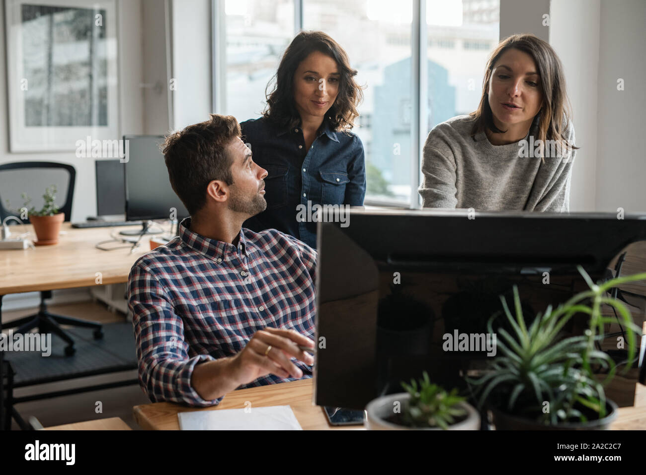 Gruppe von verschiedenen jungen Designern gemeinsam auf einem Computer Stockfoto