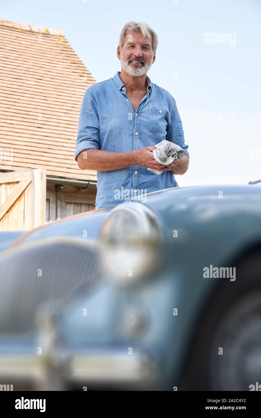 Portrait von reifer Mann Wiederherstellung der Sportwagen im Freien zu Hause Stockfoto