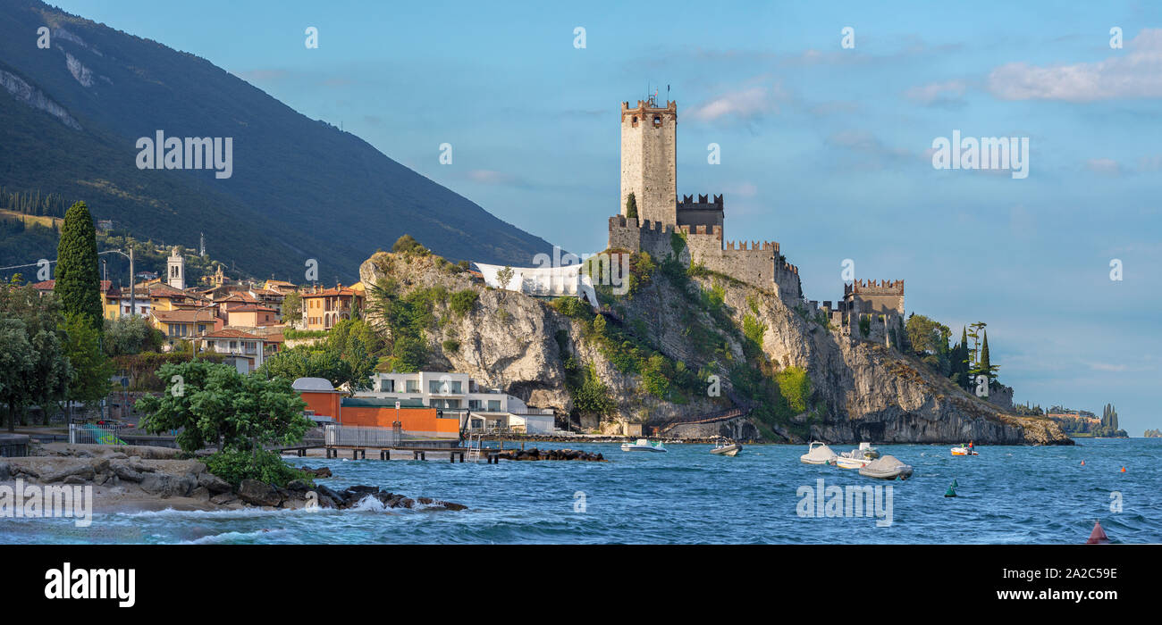 Malcesine - der Strand des Lago di Garda See, die Stadt und die Burg im Hintergrund. Stockfoto