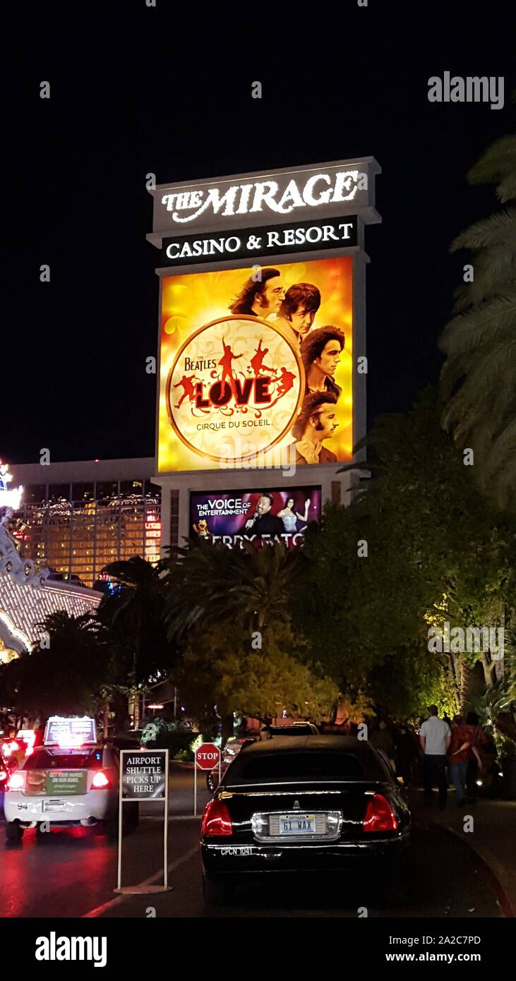 Limos kommen nachts vor dem beleuchteten Schild für das Mirage Casino in Las Vegas, Nevada, 13. März 2016 an. () Stockfoto