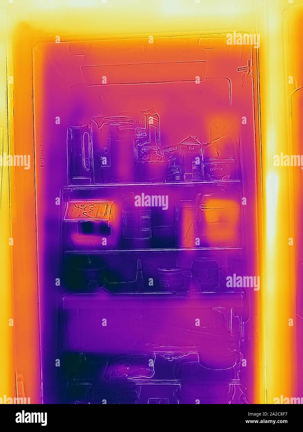 Thermografiebild der Wärmebildkamera, mit Lichtbereichen, die höheren Temperaturen entsprechen und heiße und kalte Stellen in einem Küchenkühlschrank in San Ramon, Kalifornien, September 2019 zeigen. () Stockfoto