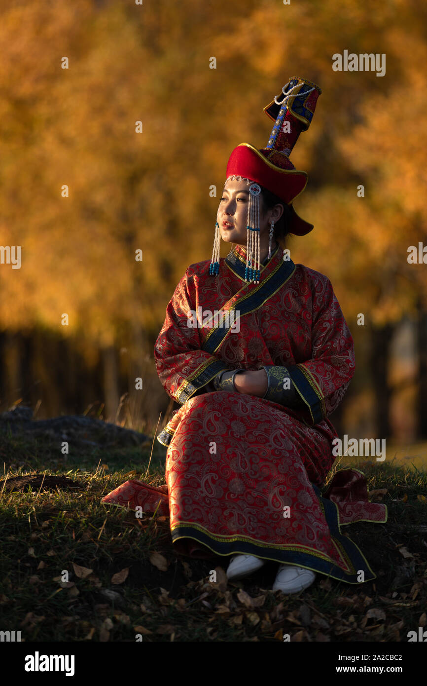 Schöne junge Frau in traditionellen mongolischen Kleid im Abendlicht posieren. Ulaanbaatar, Mongolei. Stockfoto