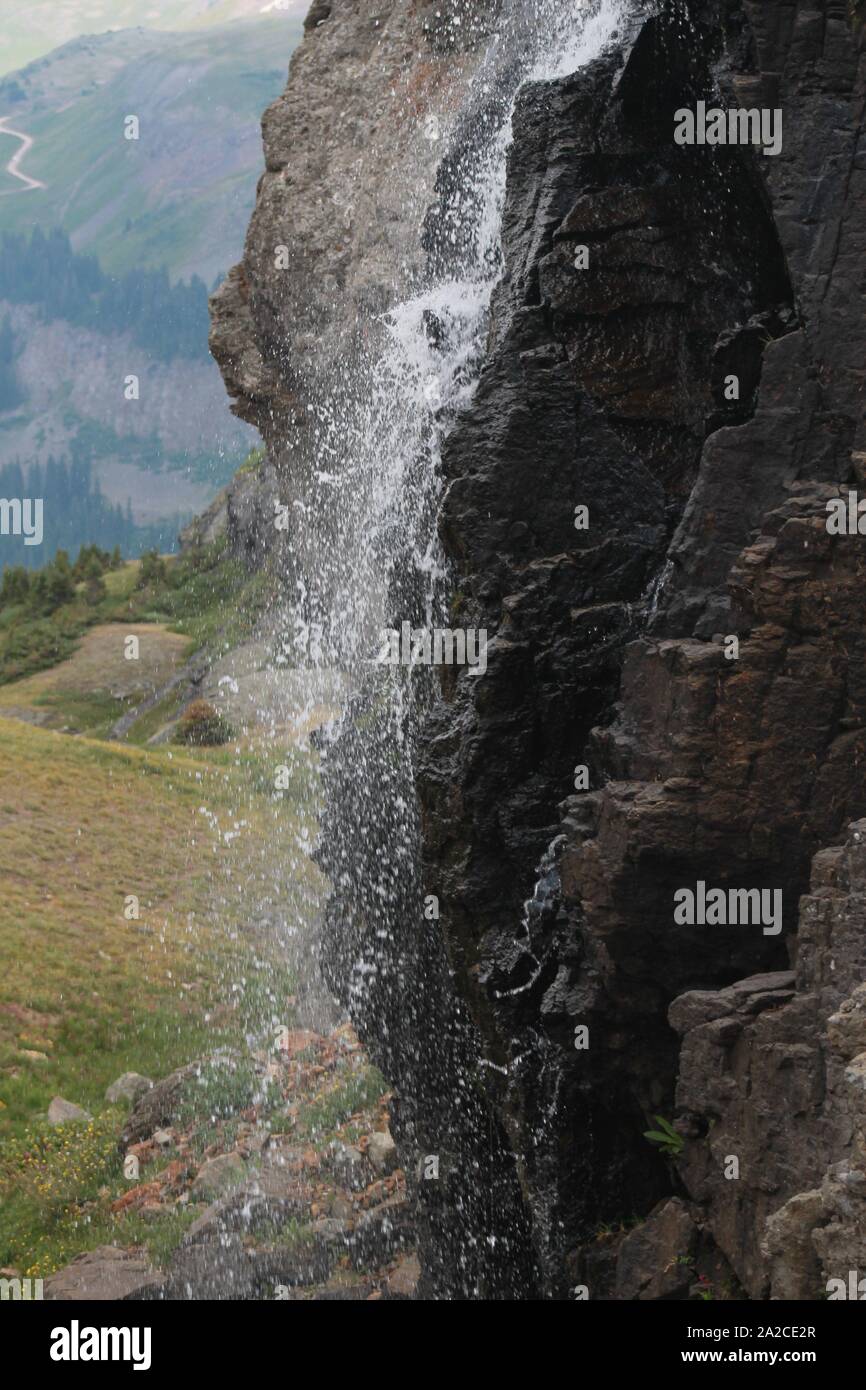 Wasserfall Tröpfelt aus dunklen Felsen auf Colorado Mountainside Stockfoto