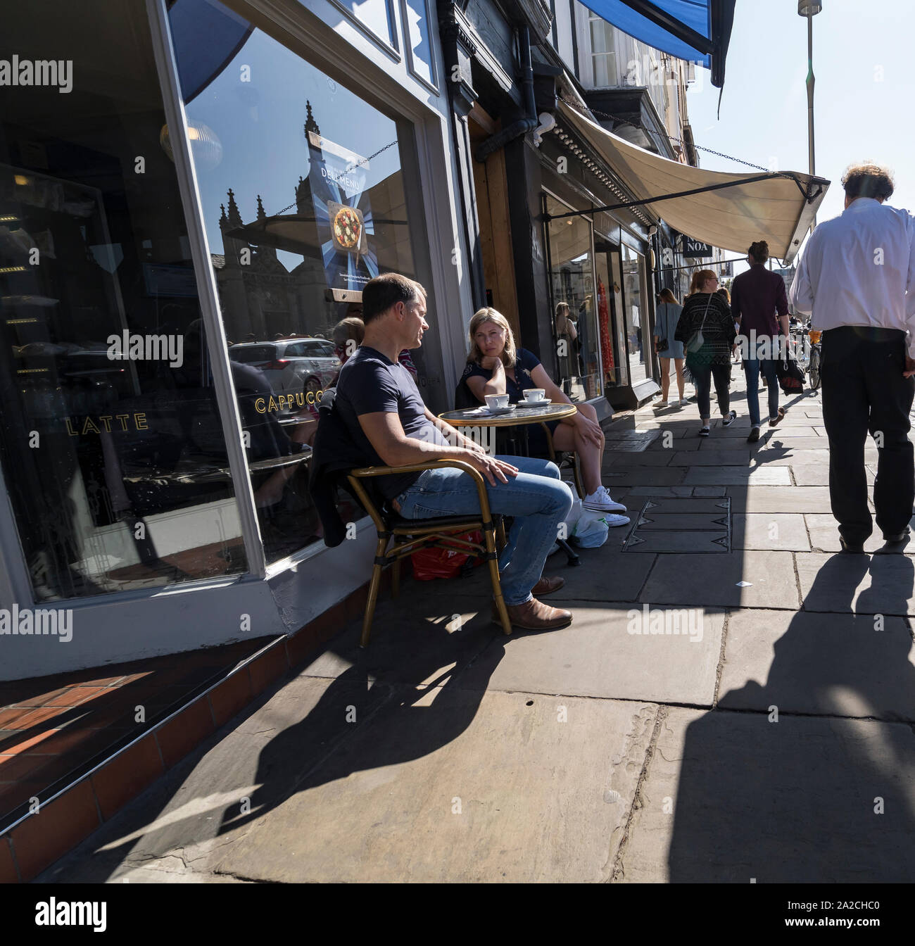 Zwei Leute saßen am Bürgersteig Tabelle Gespräch bei einem Kaffee Könige parade Cambridge 2019 Stockfoto