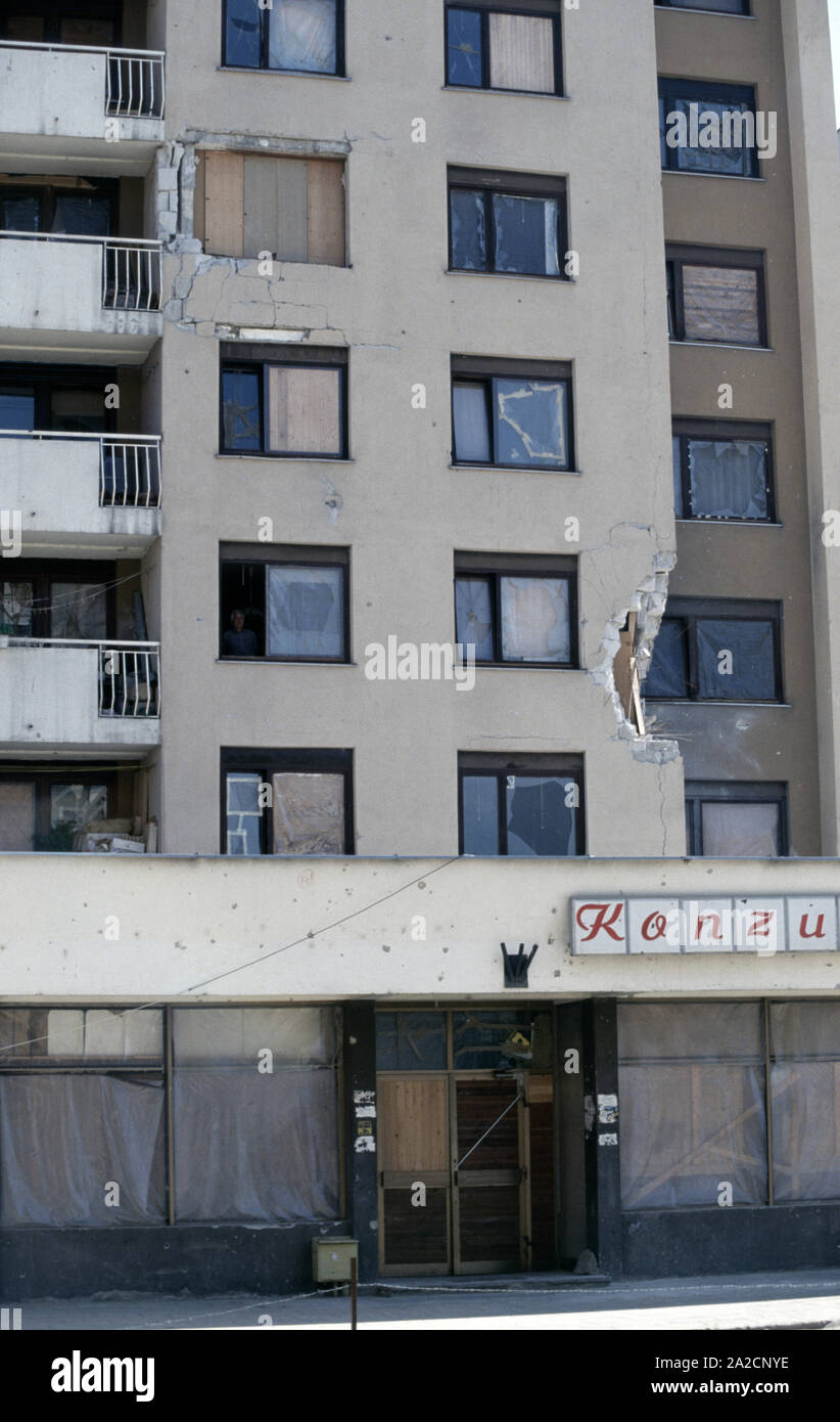 2. Juni 1993 während der Belagerung von Sarajevo: Ein alter Mann schaut durch ein geöffnetes Fenster in einem Wohnblock in dobrinjski. Fast an der Front, jedes Fenster ist aufgrund von bosnisch-serbischen Mörtel bomben Sprengsätzen gebrochen. Stockfoto