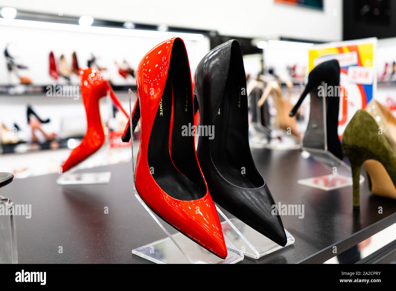Tscheljabinsk, Russland - August 2019. Rote Schuhe mit hohen Absätzen. Reihen von Schön, elegant, farbigen Damen Schuhe im Regal. Frauen schuh Stor Stockfoto