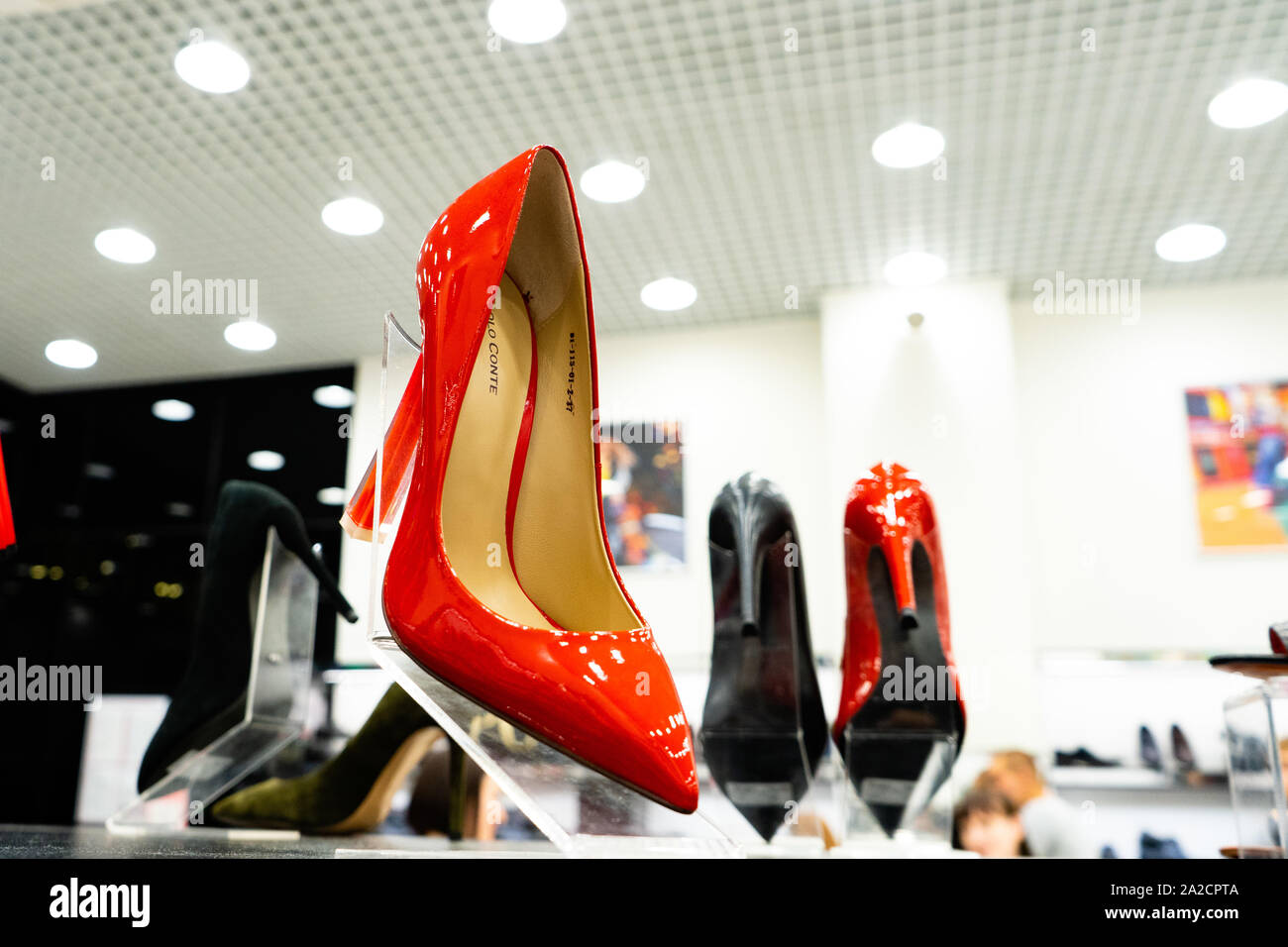 Tscheljabinsk, Russland - August 2019. Rote Schuhe mit hohen Absätzen. Reihen von Schön, elegant, farbigen Damen Schuhe im Regal. Frauen schuh Stor Stockfoto