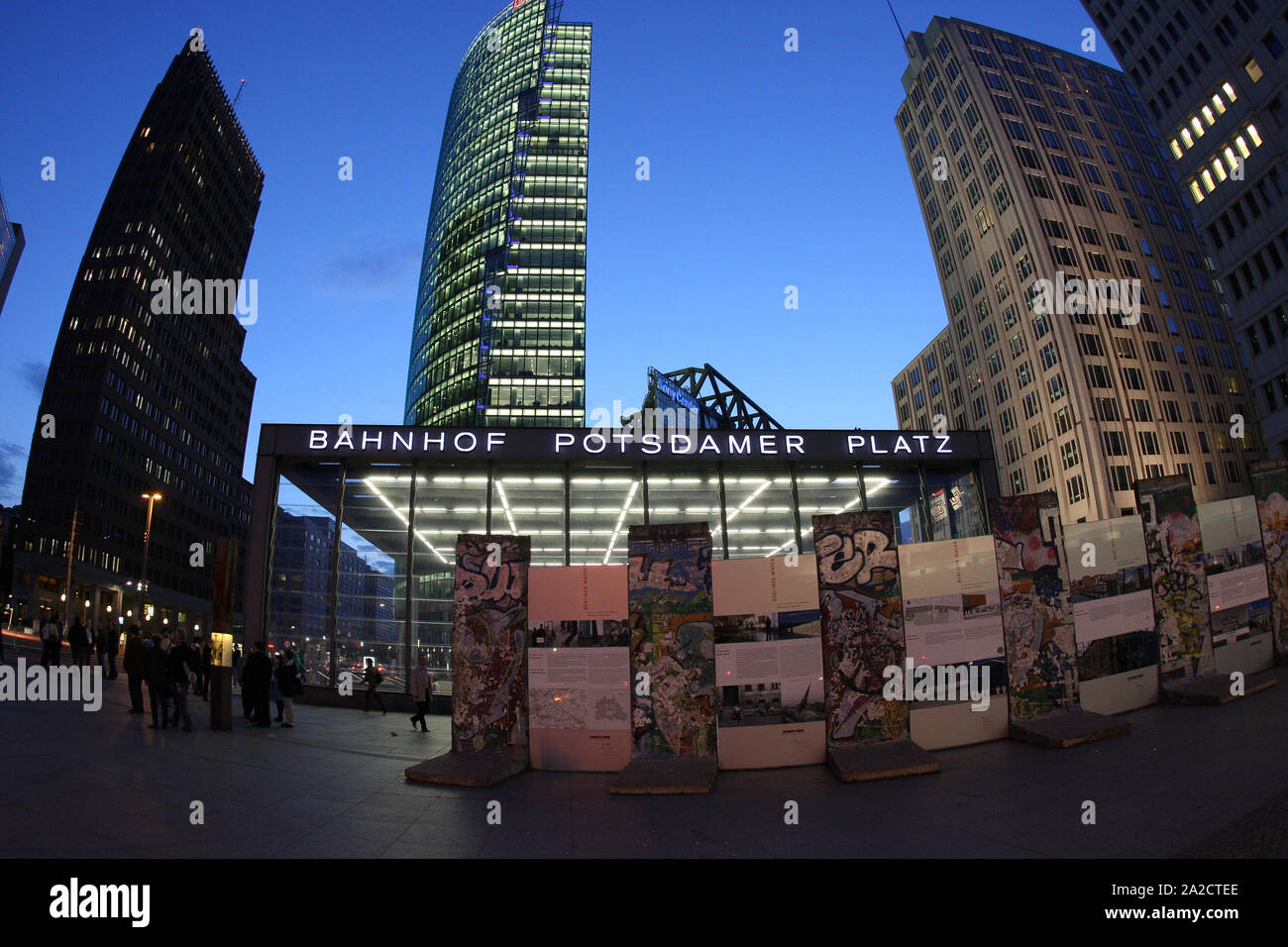 Bild der U-Bahn-Haltestelle Potsdamer Platz in Berlin während der blauen Stunde mit antiken Stücken der ursprünglichen Berliner Mauer im Vordergrund Stockfoto