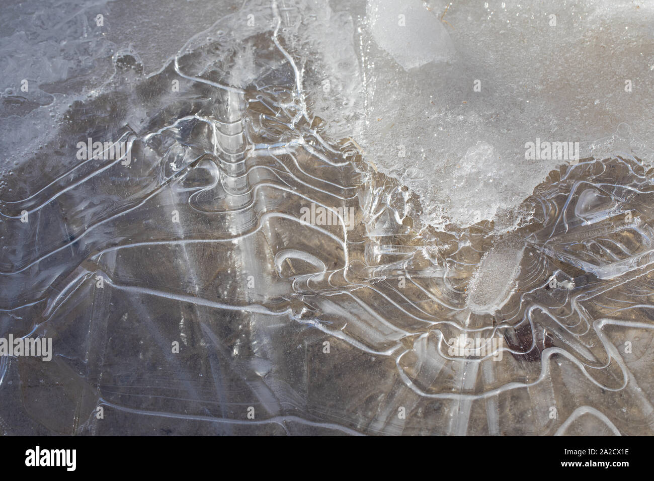 Eisentwürfe in einem Puddle auf einer Straße Stockfoto