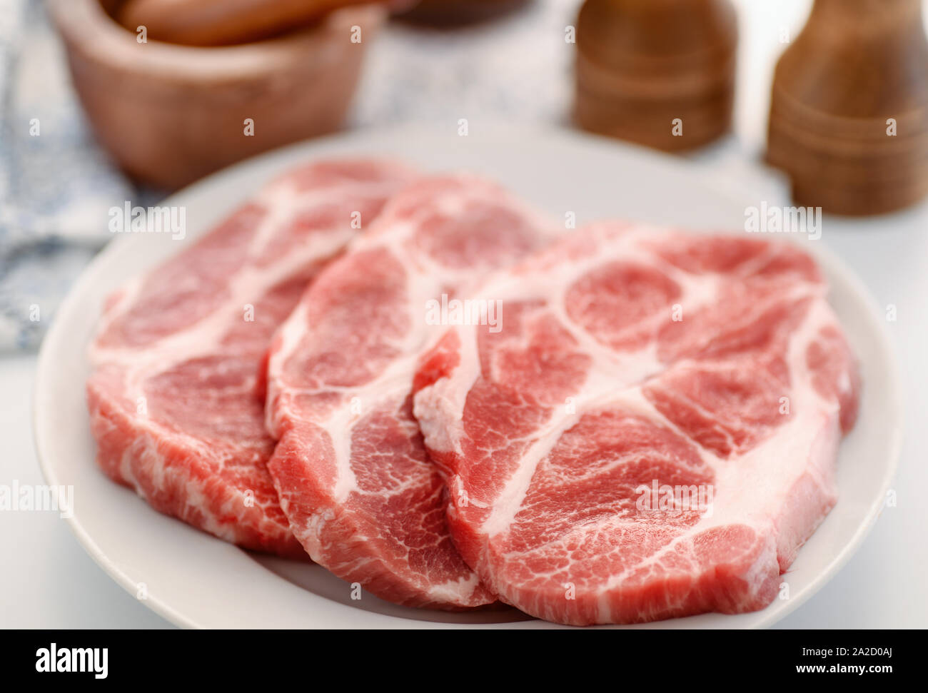 Nahaufnahme von Rohe frische Schweinekamm Fleisch Steaks auf dem Teller Stockfoto