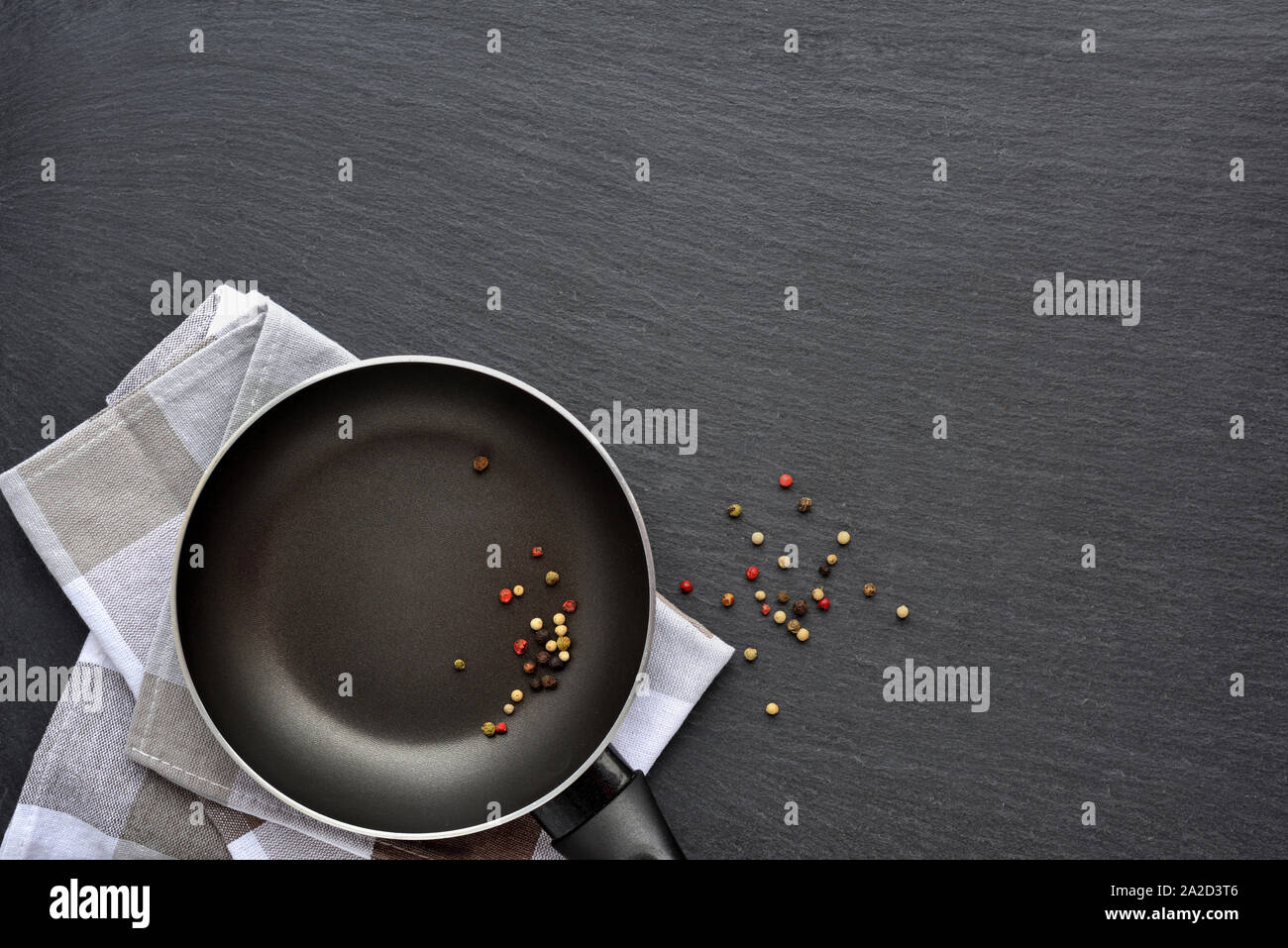 Leere Pfanne mit Serviette und mix Paprika auf dunklen grauen Stein Hintergrund. Ansicht von oben Stockfoto