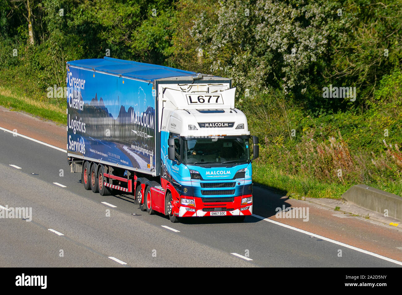 Nein L677 Malcolm Logistics Services. Umweltfreundlicher, sauberer, Lastkraftwagen für den schweren Schüttguttransport, SCANIA knickgelenkter Lastkraftwagen, Transport, Lkw, Fracht, Lieferfahrzeug, Transport, Industrie, Lieferkette Fracht, auf der M6 in Lancaster, Großbritannien Stockfoto