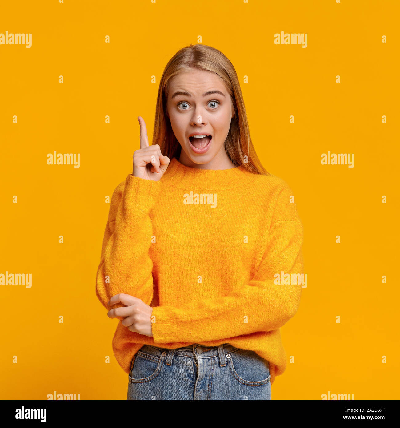 Emotionale teen Finger nach oben zeigen auf orangem Hintergrund, Idee Stockfoto