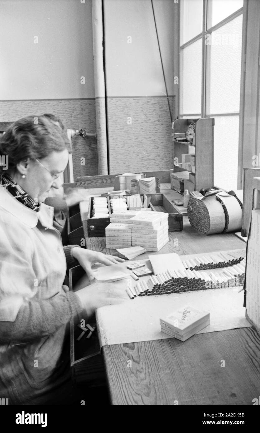 Hotels Landkarte Veranstaltungen Webcams Wetter News packt eine fertig produzierte Zigaretten der Zigarettenmarke Astra Kyriazi Zigarettenschachteln in der Zigarettenfabrik in Hamburg, Deutschland 1930er Jahre. Mitarbeiterin Verpackung zigarettenpackungen am Kyriazi Zigarettenfabrik in Hamburg, Deutschland 1930. Stockfoto