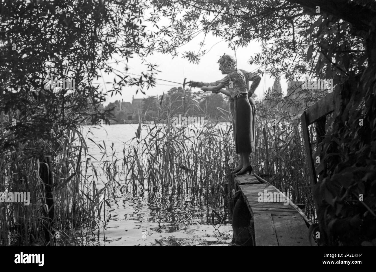 Eine Frau hört sich Tipps und Belehrungen männlicher Profi Angler eine bei einem Angelwettbewerb, Deutschland 1930er Jahre. Eine Frau, die zuhören und lernen von ihren männlichen Konkurrenten an ein Angeln Contest, Deutschland 1930. Stockfoto