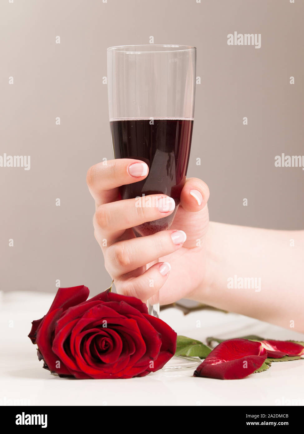 Schöne Frau hand mit polierten Nais holding Glas Rotwein Stockfoto