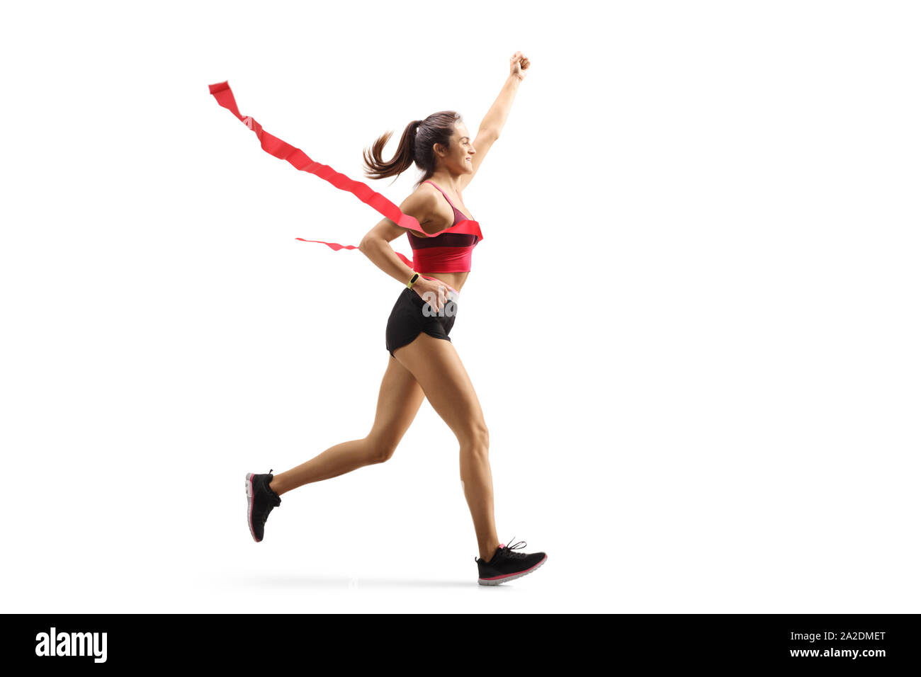 Volle Länge Profil der glückliche junge Läuferin auf der Ziellinie eines Marathons auf weißem Hintergrund Stockfoto