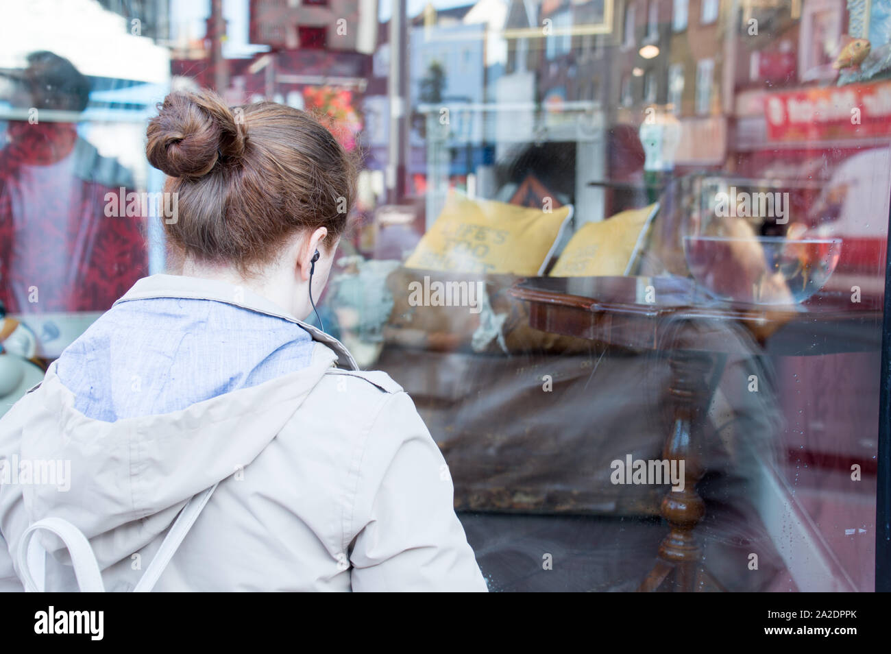Eine Dame anzeigen Banksy Kunst durch das Fenster der Shop in Croydon. Stockfoto