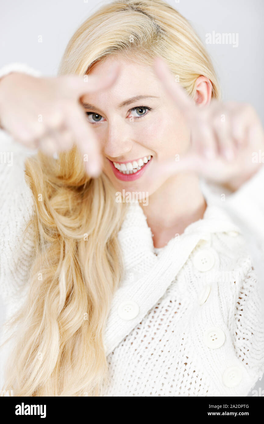 Schöne junge Frau hält ihre Hände wie ein Rahmen um ihre Augen Stockfoto