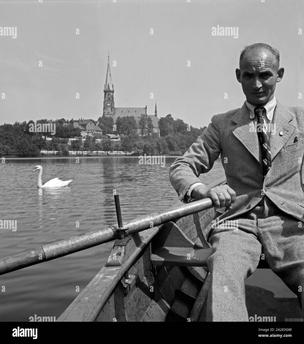 Ein Mann in einem Ruderboot mit dem Schloßteich in Chemnitz, Deutschland 1930er Jahre. Ein Mann Rudern mit dem Boot auf dem Schlossteich in Chemnitz, Deutschland 1930. Stockfoto