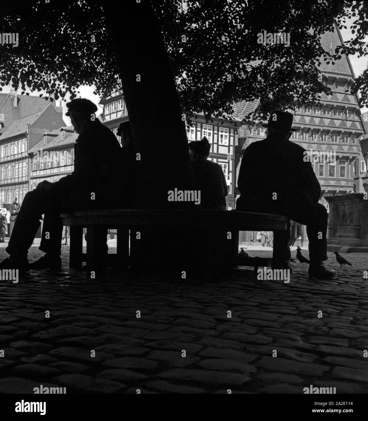 Menschen Artikel im Schatten unter einem Baum mit dem Markt bin Knochenhaueramtshaus in Hildesheim, Deutschland 1930er Jahre. Die Menschen in den Schatten am Markt in der Nähe des Metzger' Guild Hall ruht in Hildesheim, Deutschland 1930. Stockfoto