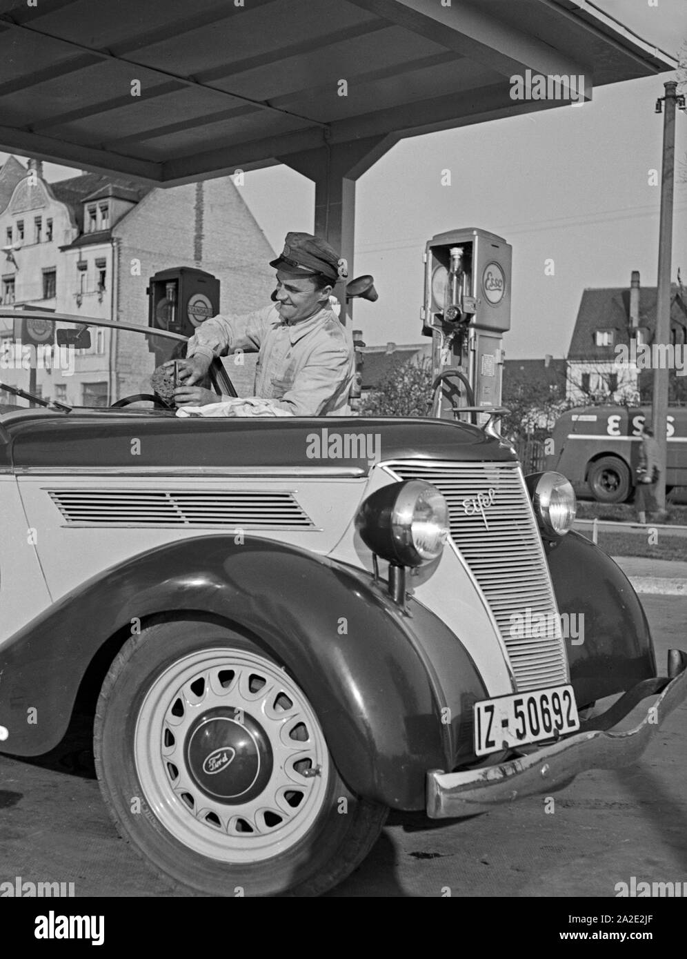 Der freundliche tankwart an der esso tankstelle wischt die