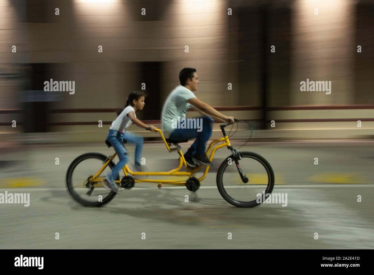 Ein Mann und eine junge Frau auf einem Tandem Fahrrad in Cali, Kolumbien. Stockfoto