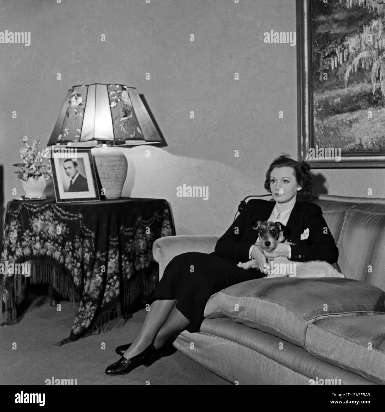 Schwedische Fictitious character und Sängerin Zarah Leander, mit ihrem Hund auf dem Sofa Sterben in ihrem Haus in Berlin, Deutschland, 1930er Jahre. Schwedische Sängerin und Schauspielerin Zarah Leander mit ihrem Hund Haustier im Sofa in Ihrem Haus in Berlin, Deutschland 1930. Stockfoto