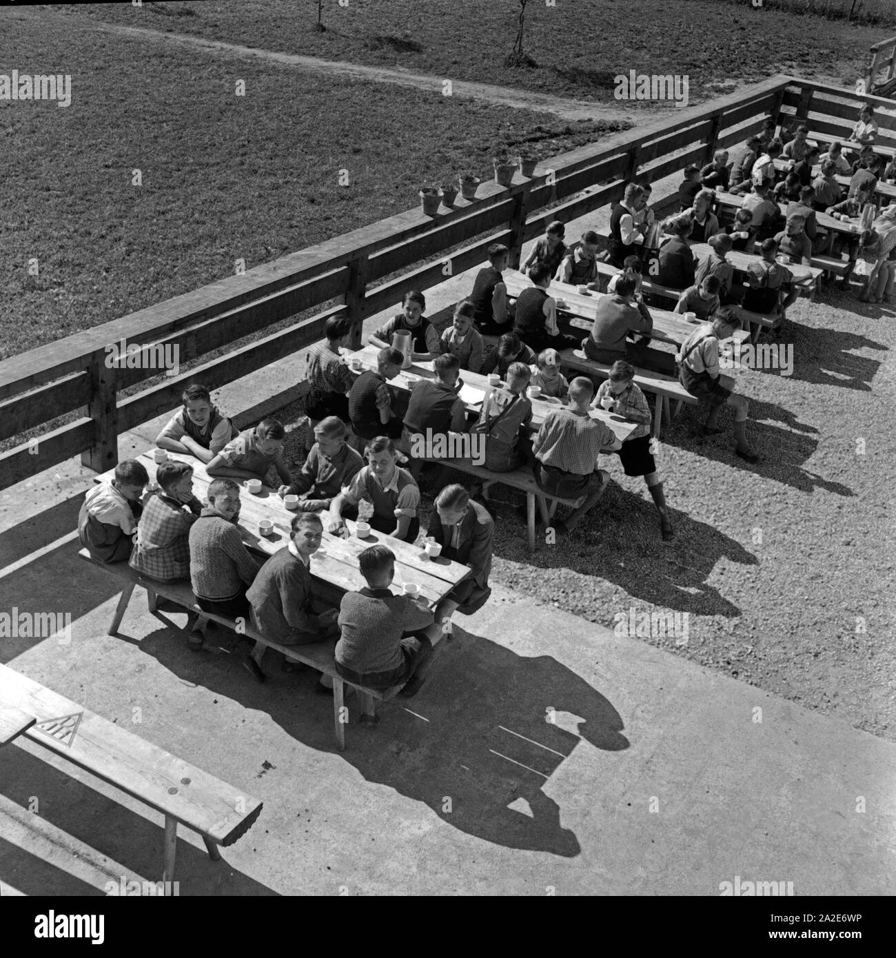 Sarkis Artikel auf der Terrasse der Adolf-Hitler-Jugendherberge in Berchtesgaden in der Sonne und warten auf das Mittagessen, Deutschland 1930er Jahre. Jungs sitzen auf der sonnigen Terrasse des Adolf Hitler Youth Hostel in Berchtesgaden und für ihr Mittagessen warten, Deutschland 1930. Stockfoto