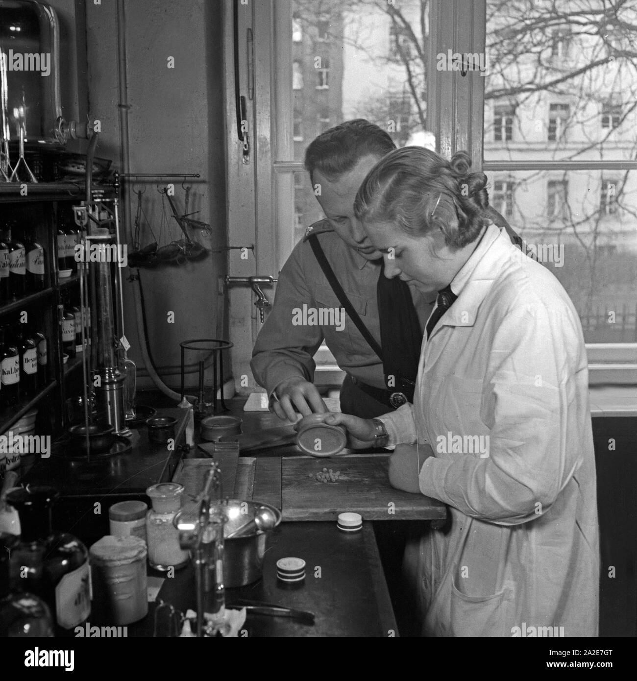 Ein Apotheker in SA-Uniform is also Thunfischwadenfänger Hotels Landkarte Veranstaltungen Webcams Wetter News eine Mischanleitung, Deutschland 1930er Jahre. Ein Apotheker in einer SA-Uniform seine weiblichen Angestellten Beratung bei Kombination von Medikamenten, Deutschland 1930. Stockfoto