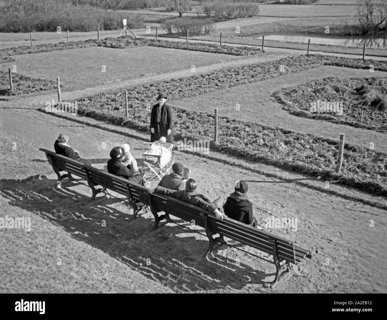 Menschen erholen sich auf einer Bank im Rosengarten in Königsberg, Ostpreußen, 1930er Jahre. Menschen, die auf der Werkbank ruhen auf einem rosery in Königsberg, Ostpreußen, 1930er Jahre. Stockfoto