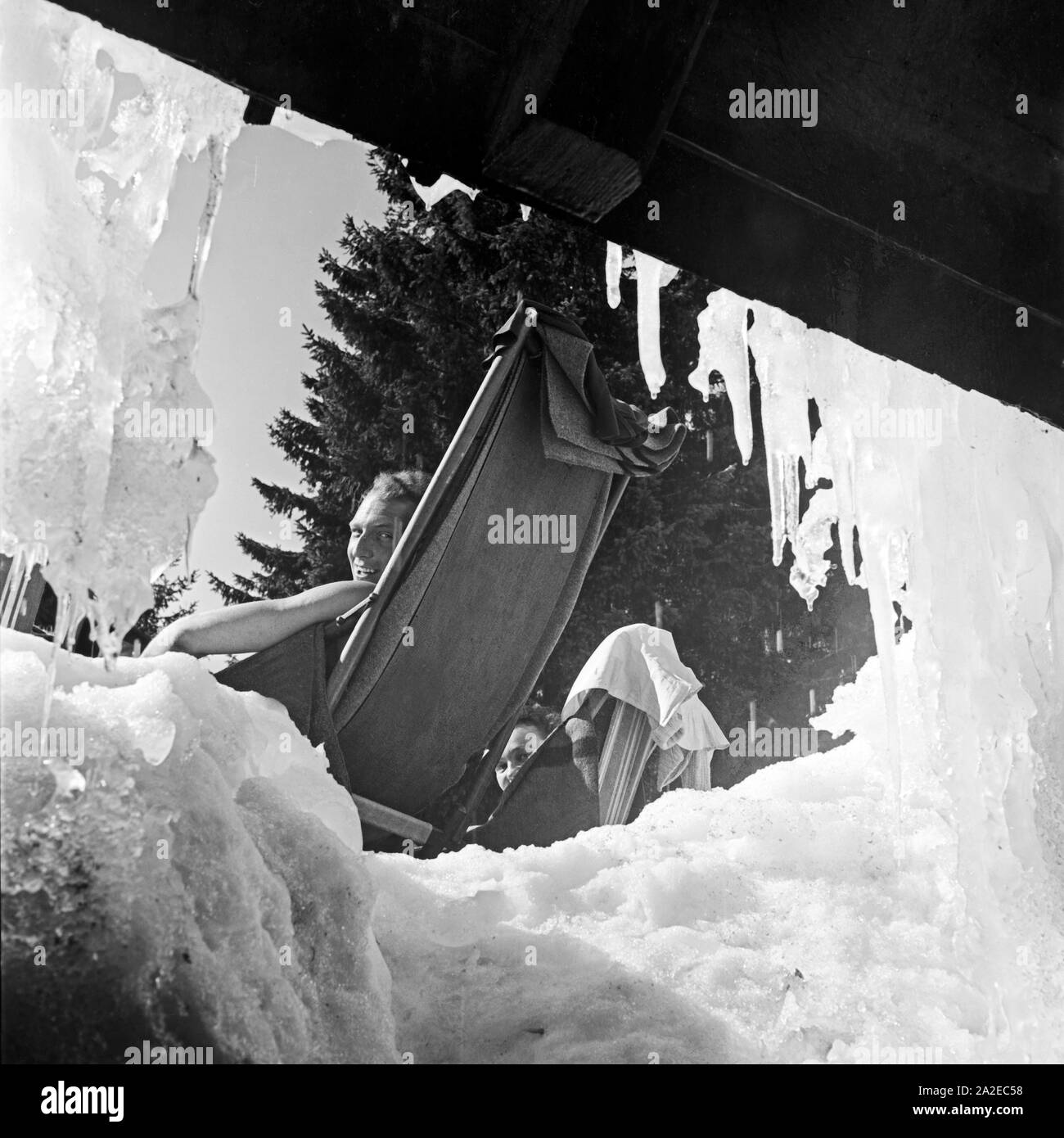 Ein Mann in einem Liegestuhl bei einer Skihütte, Deutschland 1930er Jahre. Ein Mann in einem Liegestuhl seinen Skiurlaub genießen, Deutschland 1930. Stockfoto